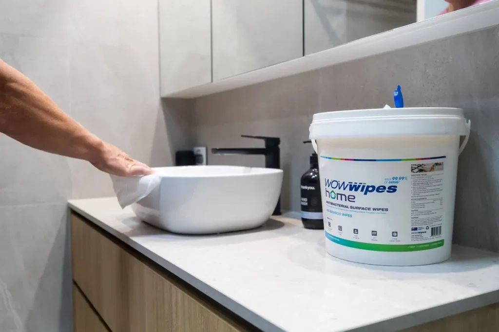 WOW Wipes® 6 Unexpected Places Where Wet Wipes Save Time hand using a WOW Wipe wet wipe to wipe down bathroom basin